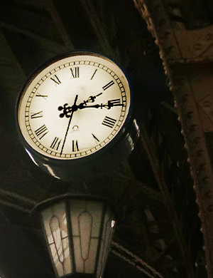 Horloge vintage surplombant un lampadaire dans une nef avec des arches en métal